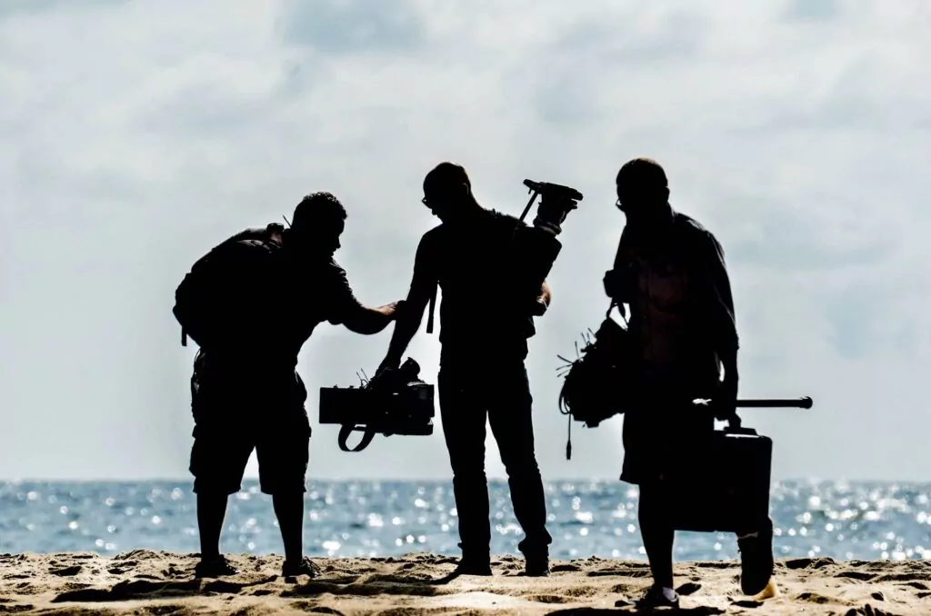 three audio visual team members walking away from event with packed equipment